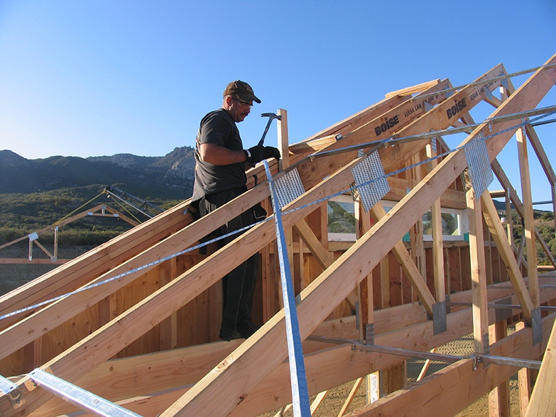 man hammering a house frame